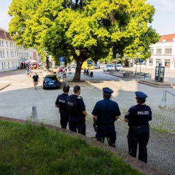 Polizisten stehen am Rande des Marktplatzes von Bad Freienwalde, wo es zu einem Angriff von Vermummten auf eine Kundgebung gekommen war.