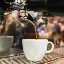 Kaffee läuft aus einer Kaffeemaschine in eine Tasse