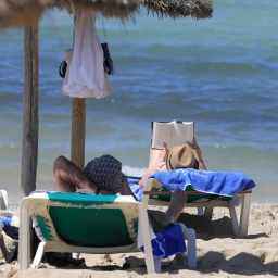 Sonnenbadende auf Liegen am Strand von Arenal auf Mallorca  