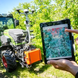 Ein Traktor, ausgestattet mit Technik aus dem Projekt &#034;SAMSON&#034; (Smarte Automatisierungssysteme und -services für den Obstanbau an der Niederelbe) fährt durch die Baumreihen.